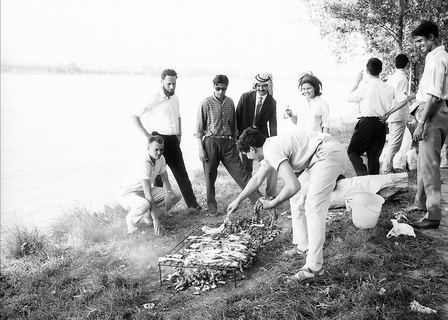 Menschen am Flussufer beim Grillen