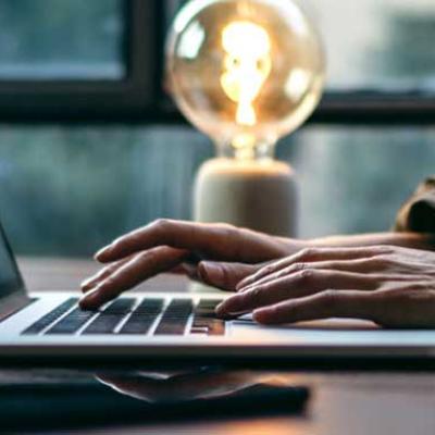 Laptop mit tippenden Händen