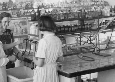 Schwarz-weiß Fotografie mehrerer Frauen in einem Labor