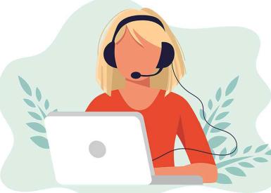 Frau mit Headset sitzt vor Laptop