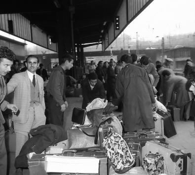 Männer mit Gepäck auf dem Gleis