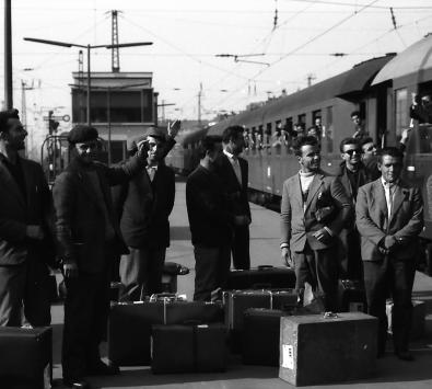 Männer mit Gepäck auf dem Gleis