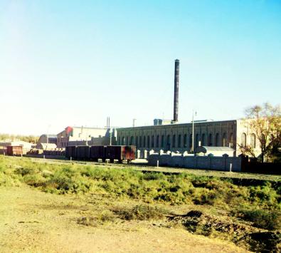Eisenbahngleise und Waggons vor einer Fabrik