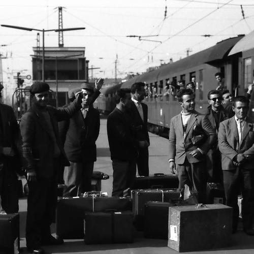 Männer mit Gepäck auf dem Gleis