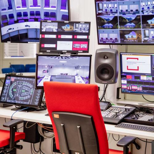 Arbeitsplatz mit mehreren Bildschirmen und Geräten