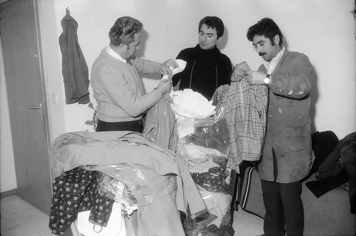 Männer bei Durchsicht von Kleiderspenden