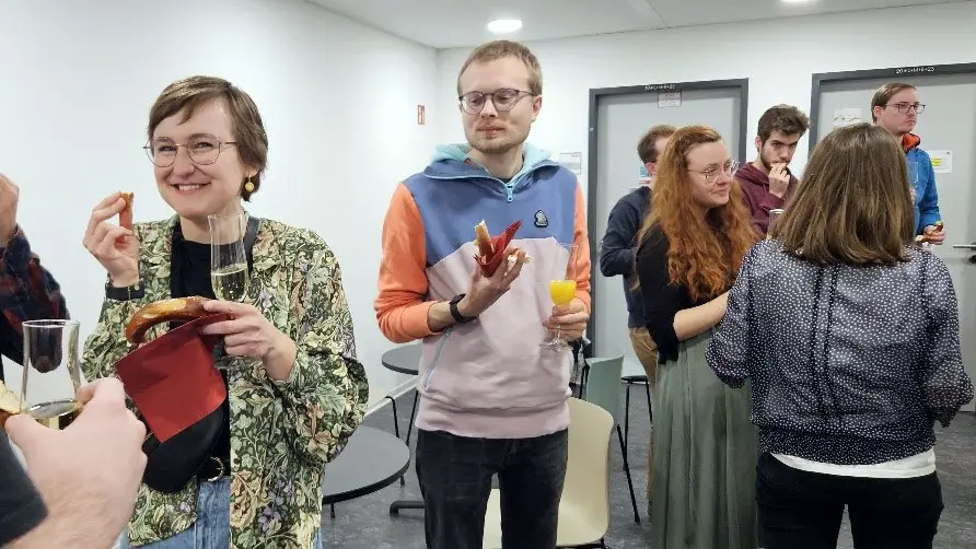 Studierende, die mit Häppchen und Getränken feiern